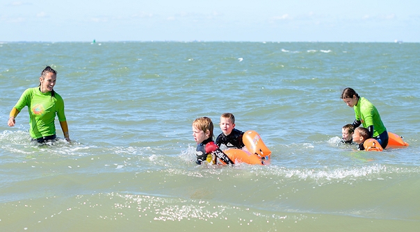 De kinderen krijgen zwemles in zee tijdens het project 'C in zee'.