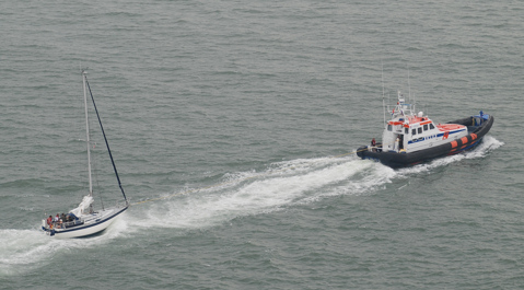 De KNRM-reddingboot heeft het jacht op sleeptouw.