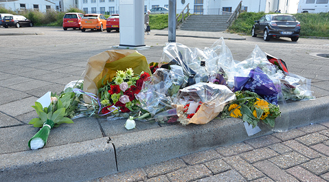 Bloemen op de plek waar het slachtoffer werd neergeschoten.