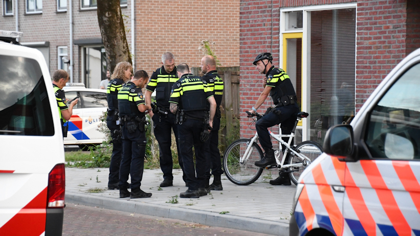 Politieagenten bij de woning waar de gewonde vrouw zich bevond.