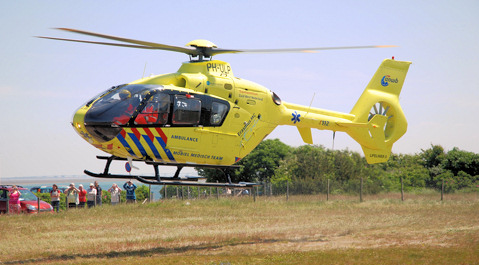 De traumahelikopter stijgt op vanaf een grasveld bij de haven.