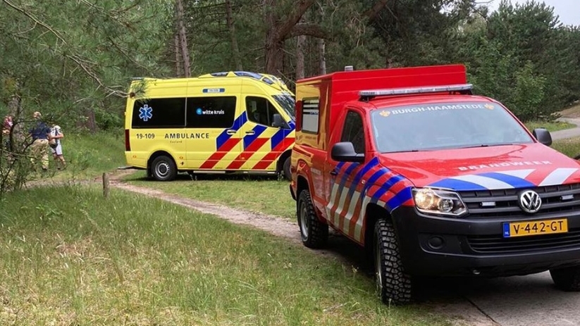De brandweer en de ambulancedienst in het bos bij een gevallen fietser.