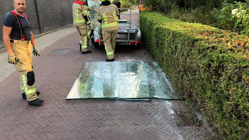 De brandweerlieden hebben de glasplaten op een aanhangwagen gelegd.